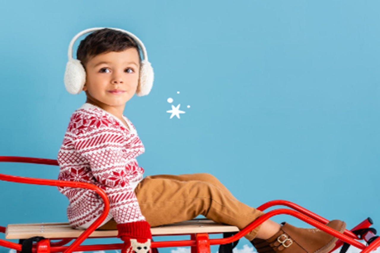 Little boy sitting on a sled.