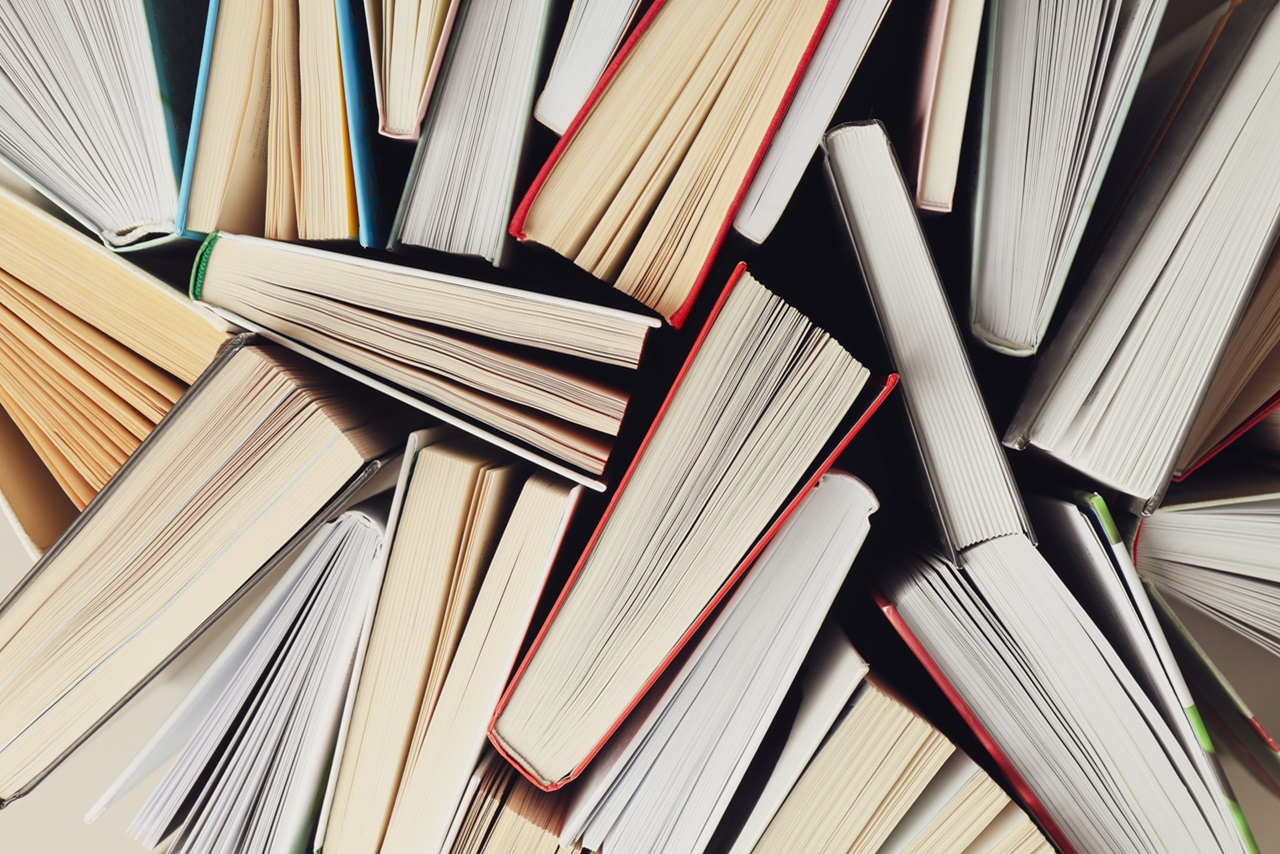 Many multicolored books stacked haphazardly