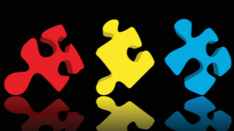 red, yellow, and blue puzzle pieces on a dark background